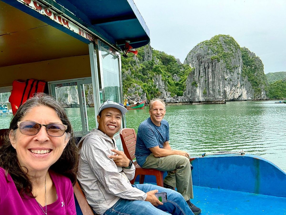With our guide on a boat among the karst cliffs With our guide on a boat among the karst cliffs