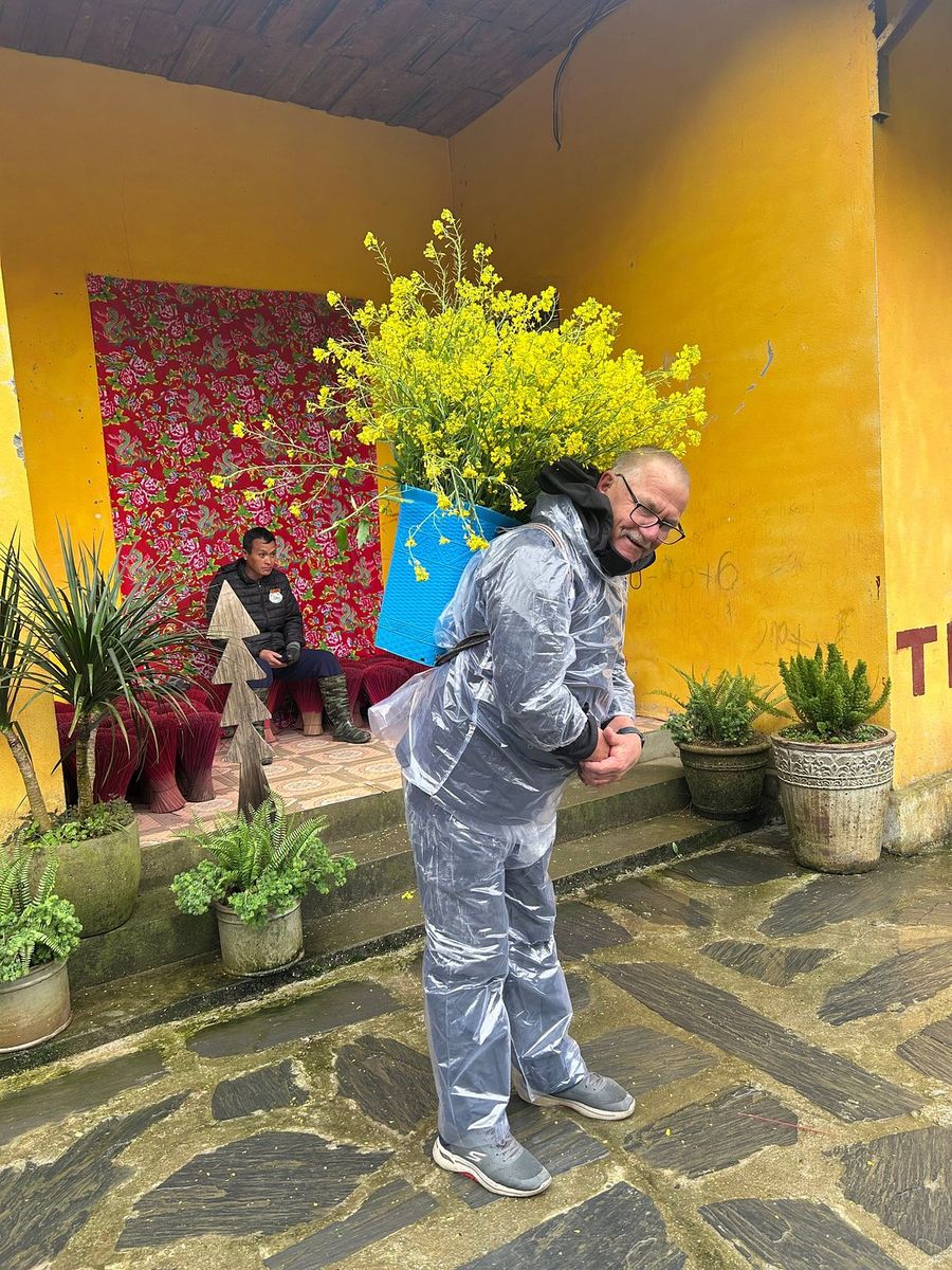 Gerard with a huge bunch of yellow flowers in a Sapa village
