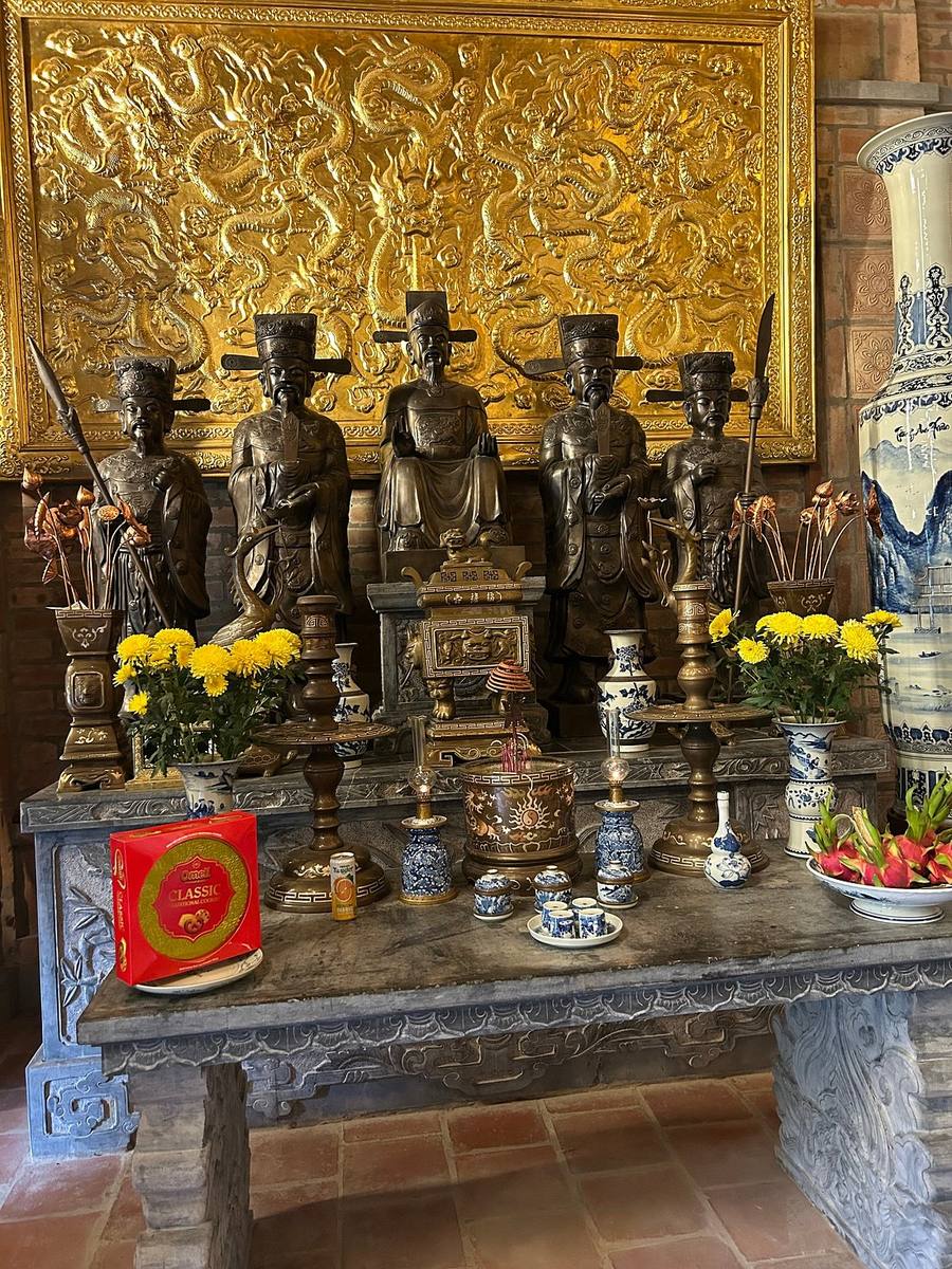 Bronze mandarin statues and offerings at a Vietnamese temple altar Bronze mandarin statues and offerings at a Vietnamese temple altar