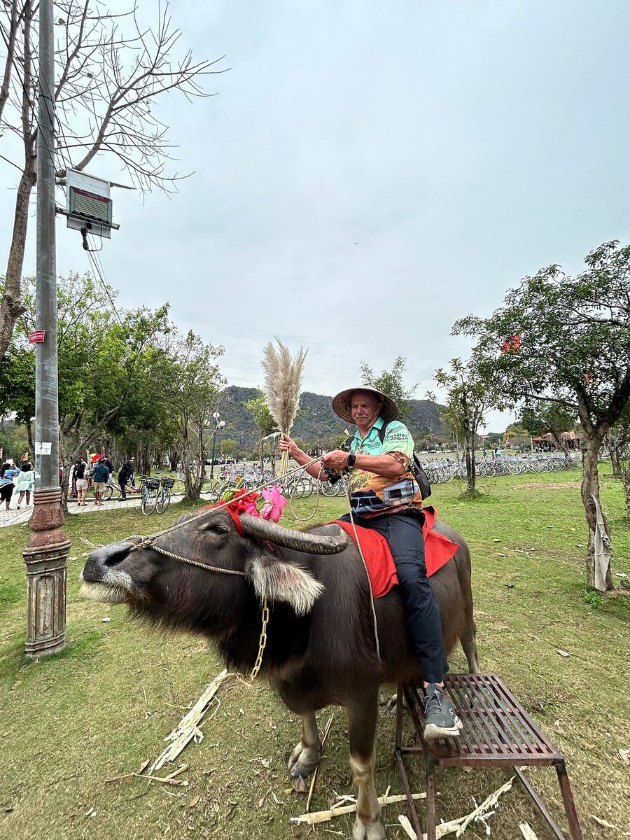 Gerard riding a water buffalo in a conical hat near Ninh Binh Gerard riding a water buffalo in a conical hat near Ninh Binh